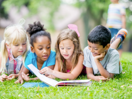 A group of young children reading a book.