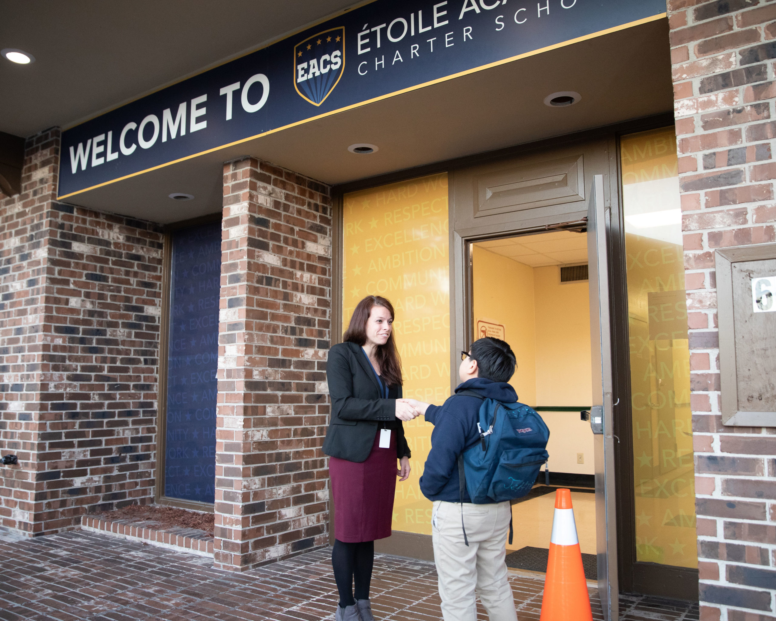 Étoile Superintendent and Lead Founder, Kayleigh Colombero, shaking the hand of a student outside of the Étoile school building. Colombero uses Possip to help inform decision making at school.